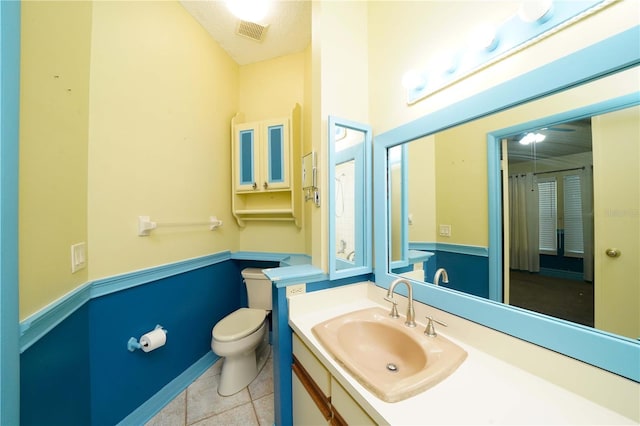 bathroom featuring a textured ceiling, toilet, vanity, and tile patterned floors