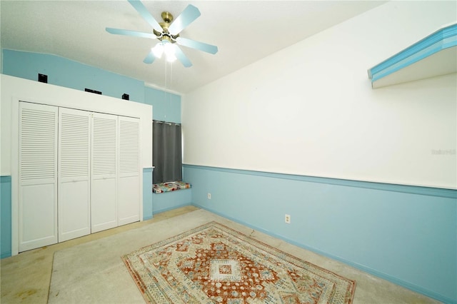 carpeted bedroom featuring lofted ceiling and a ceiling fan