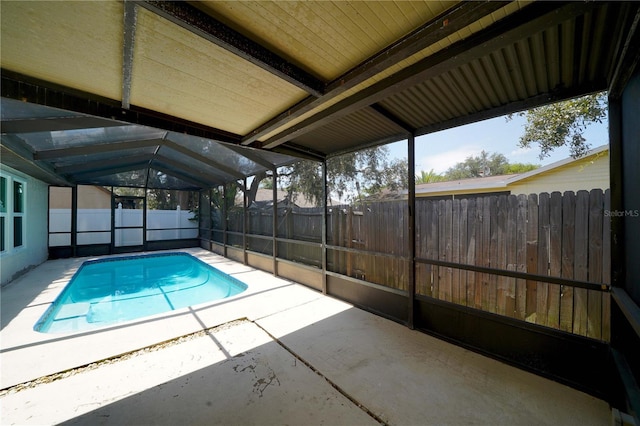 view of pool featuring glass enclosure, a patio area, a fenced backyard, and a fenced in pool