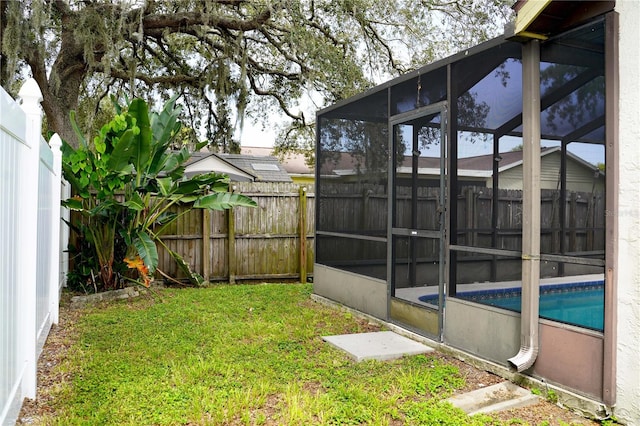 view of yard with a fenced in pool and a sunroom