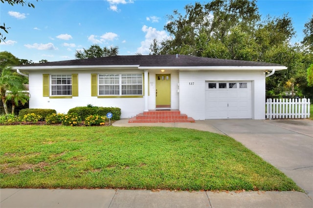 ranch-style house featuring a garage and a front yard