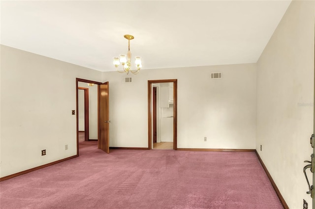 carpeted empty room featuring a notable chandelier