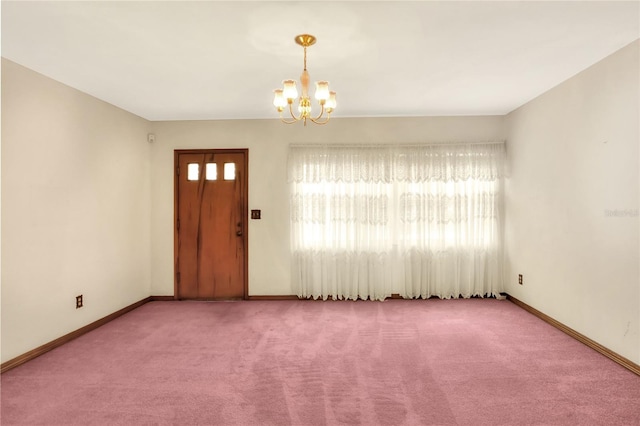 carpeted entryway with a notable chandelier