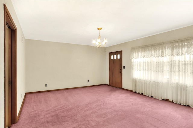 empty room featuring carpet and an inviting chandelier