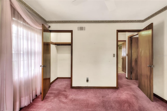 unfurnished bedroom featuring carpet, a closet, crown molding, and ceiling fan