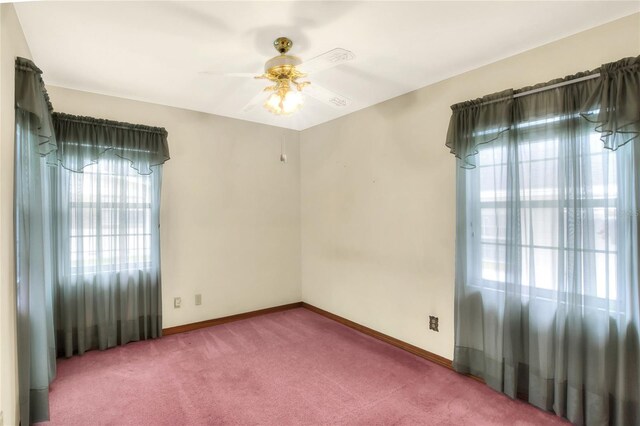 empty room featuring ceiling fan, carpet floors, and a healthy amount of sunlight