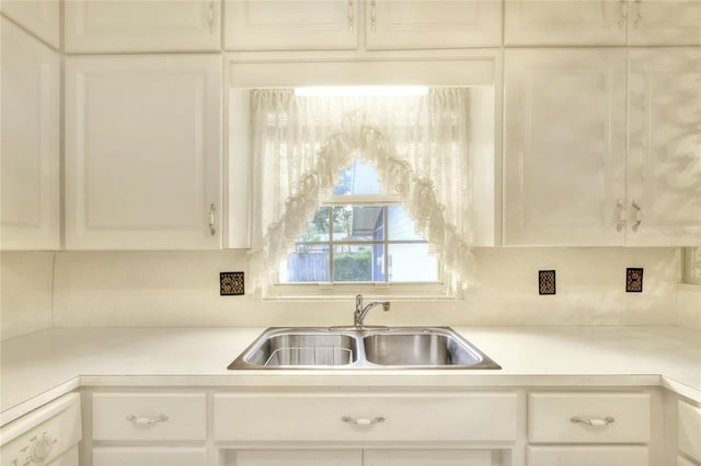 kitchen with sink, white dishwasher, and white cabinets