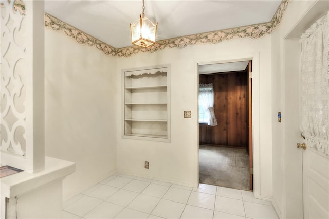 spare room featuring light tile patterned flooring and built in shelves