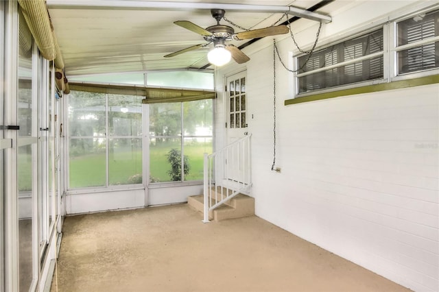 unfurnished sunroom with ceiling fan and vaulted ceiling