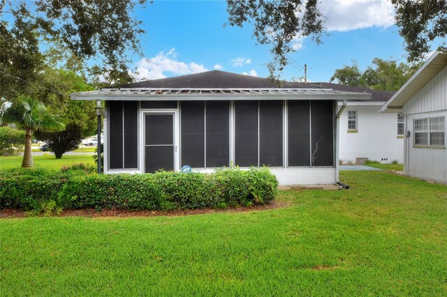 back of house featuring a sunroom and a yard