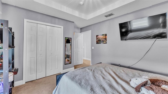 carpeted bedroom featuring baseboards and a closet