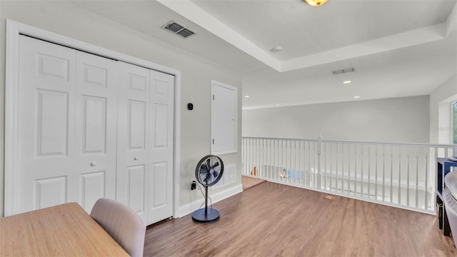 office space with wood finished floors, baseboards, a raised ceiling, and recessed lighting