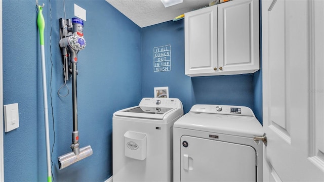 laundry area featuring cabinet space, washer and dryer, and a textured ceiling