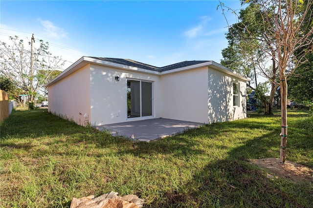 rear view of property featuring a yard and a patio area