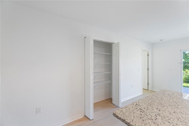 unfurnished bedroom with a closet and light hardwood / wood-style floors