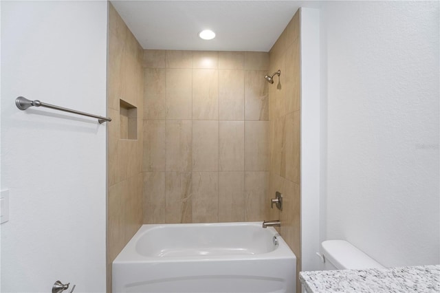 bathroom with toilet and tiled shower / bath