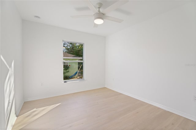 empty room with ceiling fan and light hardwood / wood-style flooring