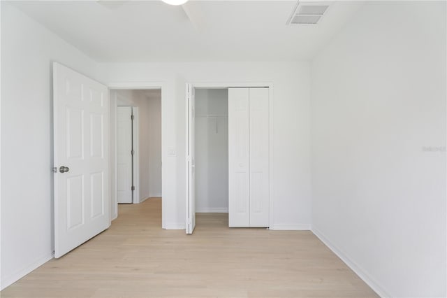 unfurnished bedroom featuring light hardwood / wood-style floors, a closet, and ceiling fan