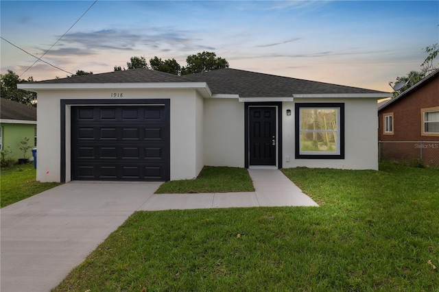 ranch-style home featuring roof with shingles, stucco siding, a garage, driveway, and a front lawn