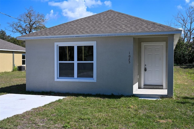 exterior space with cooling unit and a lawn