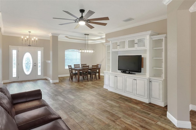 living room with light hardwood / wood-style flooring, ceiling fan with notable chandelier, and ornamental molding