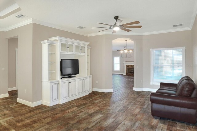 unfurnished living room featuring dark hardwood / wood-style flooring, plenty of natural light, and crown molding