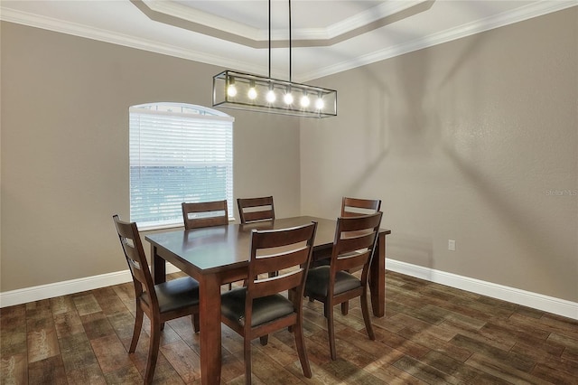 dining space with a raised ceiling, crown molding, and dark wood-type flooring