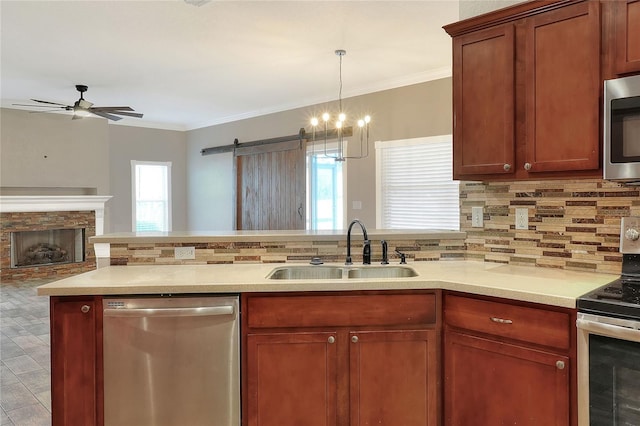 kitchen featuring a barn door, crown molding, sink, and stainless steel appliances