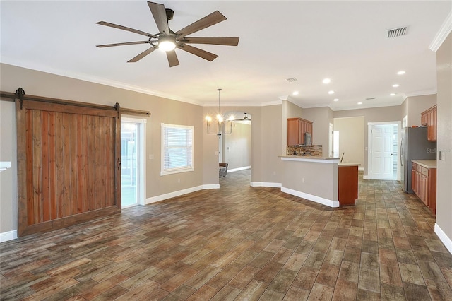 interior space with ceiling fan with notable chandelier, a barn door, dark hardwood / wood-style flooring, and ornamental molding