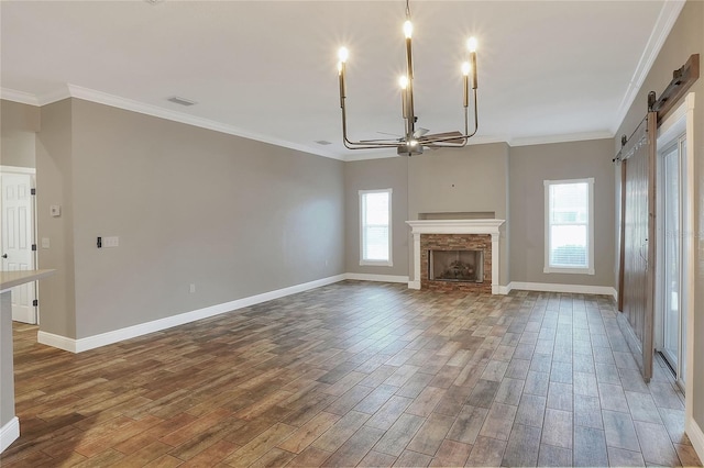 unfurnished living room featuring a barn door, crown molding, ceiling fan, and dark wood-type flooring