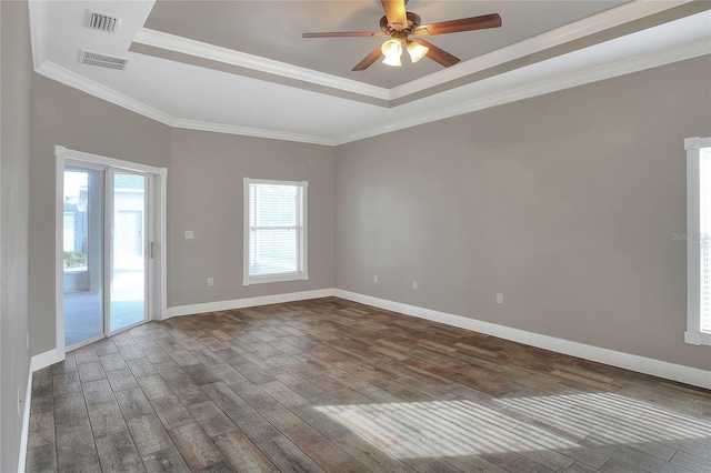 unfurnished room with a healthy amount of sunlight, ornamental molding, and dark wood-type flooring