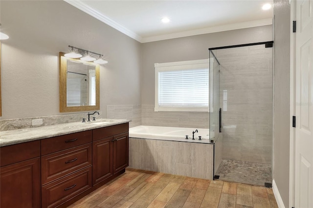 bathroom with plus walk in shower, hardwood / wood-style floors, vanity, and ornamental molding