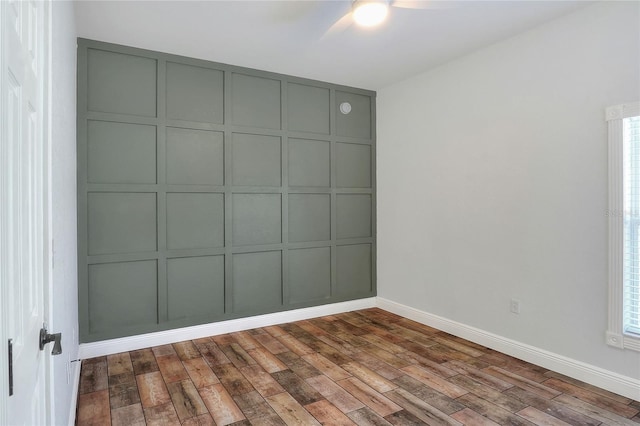 unfurnished room with ceiling fan and dark wood-type flooring