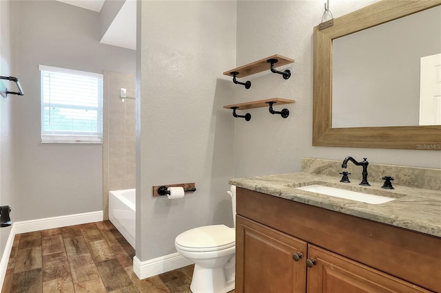 full bathroom with vanity, toilet, wood-type flooring, and tiled shower / bath combo