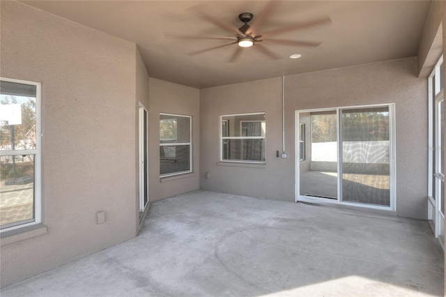 unfurnished sunroom featuring ceiling fan