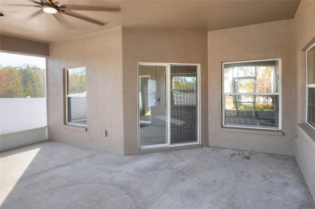 unfurnished sunroom with ceiling fan