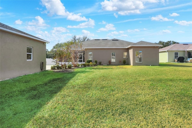 rear view of property with a lawn