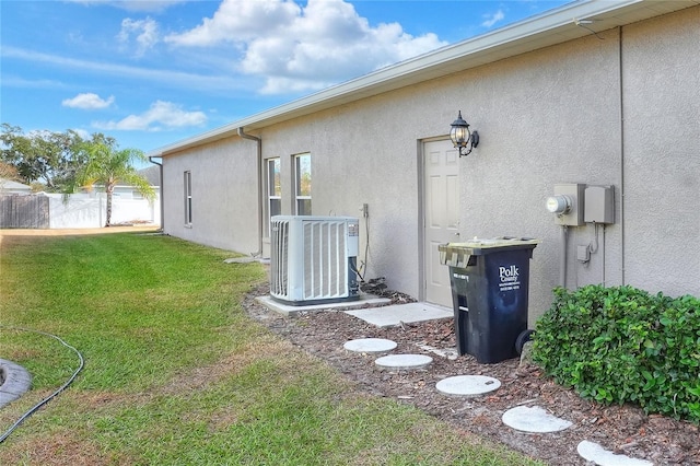 view of home's exterior with central AC unit and a yard