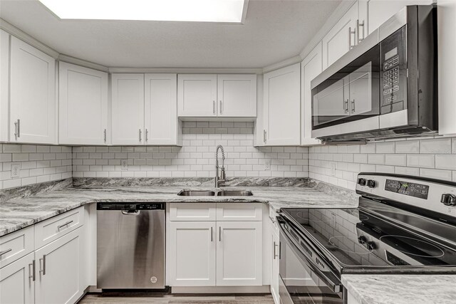 kitchen featuring white cabinets, stainless steel appliances, tasteful backsplash, and sink