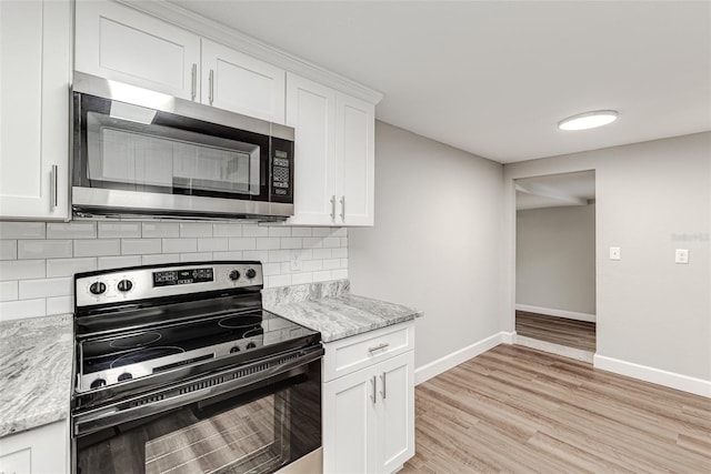 kitchen featuring white cabinets, stainless steel appliances, decorative backsplash, and light hardwood / wood-style floors