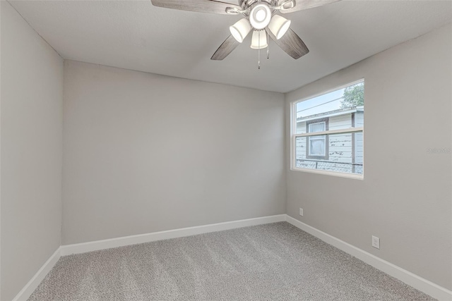 empty room with carpet, ceiling fan, and baseboards