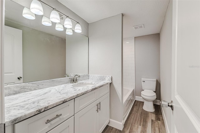 full bathroom featuring visible vents, toilet, shower / tub combination, wood finished floors, and vanity