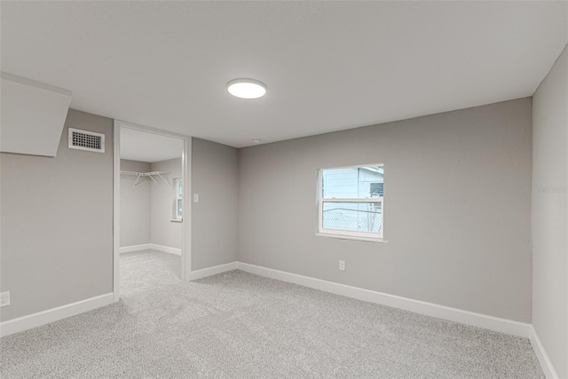 unfurnished bedroom featuring baseboards, a closet, visible vents, and light colored carpet