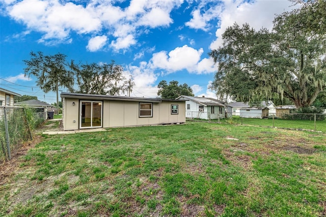 back of property with a lawn and a fenced backyard