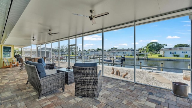 sunroom featuring a water view and ceiling fan