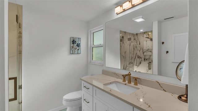 bathroom featuring vanity, toilet, and a tile shower