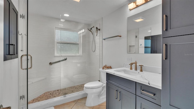 bathroom with vanity, toilet, walk in shower, and tile patterned flooring