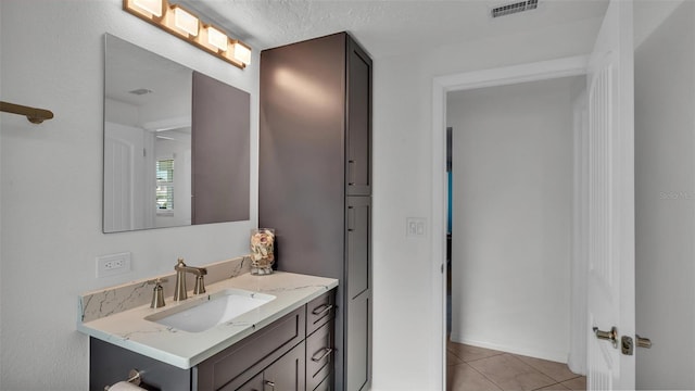 bathroom featuring tile patterned flooring, vanity, and a textured ceiling