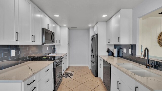 kitchen featuring light stone counters, sink, appliances with stainless steel finishes, and white cabinets