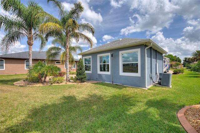 rear view of house featuring a yard and central air condition unit